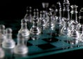 glass chess pieces are defending the king on board in dark Royalty Free Stock Photo