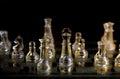 Glass chess pieces are defending the king on board in dark Royalty Free Stock Photo