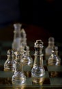 glass chess pieces are defending the king on board in dark Royalty Free Stock Photo