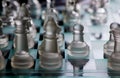 Glass chess pieces are defending the king on board in dark Royalty Free Stock Photo