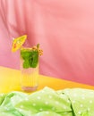 Glass of chill sparkling water, mojito cocktail with fresh mint, lime and rom isolated on pink background. Summer drink. Royalty Free Stock Photo