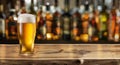 Glass of chilled beer on table and blurred sparkling bar background