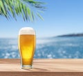 Glass of chilled beer on table and blurred sparkling sea at the background. Place for your product or brand name display Royalty Free Stock Photo