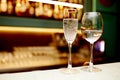 A glass of chilled champagne in a crystal glass is on the bar, next to it is a crystal glass for water with water inside against