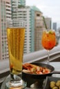 Glass of Chilled Draft Beer with Blurry Fresh Fruits Sangria Cocktail and Tapas at the Rooftop Bar Terrace