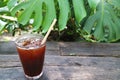 Glass of Chilled Iced Coffee on Garden Wooden Table