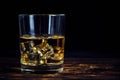 Glass chilled whiskey with ice cubes on wooden background in cellar