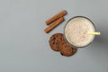 Glass of chocolate milkshake, cookies and cinnamon on gray background Royalty Free Stock Photo