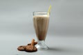 Glass of chocolate milkshake, cookies and cinnamon on gray background Royalty Free Stock Photo