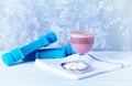 Glass of Chocolate Protein Shake with milk and black currant . L - Carnitine and blue dumbbells in background Royalty Free Stock Photo