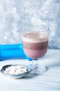 Glass of Chocolate Protein Shake with milk and black currant. L - Carnitine and blue dumbbells in background. Sport nutrition Royalty Free Stock Photo