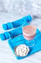 Glass of Chocolate Protein Shake with milk and black currant . L - Carnitine and blue dumbbells in background. Royalty Free Stock Photo