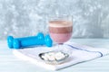 Glass of Chocolate Protein Shake with milk and black currant. L - Carnitine and blue dumbbells in background Royalty Free Stock Photo