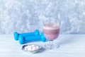 Glass of Chocolate Protein Shake with milk and black currant . L - Carnitine and blue dumbbells in background Royalty Free Stock Photo