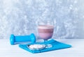 Glass of Chocolate Protein Shake with milk and black currant . L - Carnitine and blue dumbbells in background Royalty Free Stock Photo