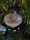 Glass Christmas bauble hanging on a pine tree