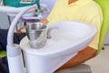 Glass chromium on Sink medical equipment dentist Close up, ceramic spittoon and water filler in Clinic Royalty Free Stock Photo