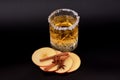 A glass of cider with sugar around the rim and slices of a ripe apple with cinnamon and anise on a black background Royalty Free Stock Photo