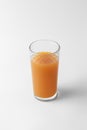 Glass with citrus juice of orange color isolated on a white and gray background with natural shadow