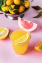 Glass of Citrus Juices Detox Diet Healthy Drink Mandarine Lemon and Grapefruit Juices Raw Mandarines Pink Background Vertical Royalty Free Stock Photo