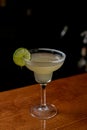 Glass of classic daiquiri cocktail with lime on a bar counter Royalty Free Stock Photo