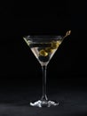 Glass of classic dry martini cocktail with olives on dark stone table against a black background Royalty Free Stock Photo