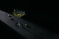 Glass of classic dry martini cocktail with olives on dark stone table against a black background. Royalty Free Stock Photo