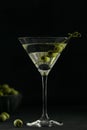 Glass of classic dry martini cocktail with olives on dark stone table against a black background. Royalty Free Stock Photo