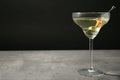 Glass of Classic Dry Martini with olives on grey table  black background. Space for text Royalty Free Stock Photo