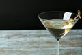 Glass of Classic Dry Martini with olives on wooden table against black background, closeup Royalty Free Stock Photo