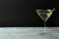 Glass of Classic Dry Martini  olives on wooden table against black background. Space for text Royalty Free Stock Photo