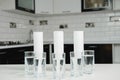 A glass of clean water with osmosis filter and cartridges on white table in a kitchen interior. Concept Household filtration Royalty Free Stock Photo