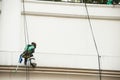 Glass cleaner abseiling from a tall building. Window cleaners at Royalty Free Stock Photo