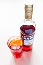 Glass with cocktail and closed bottle of Campari