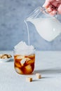 Glass of coffee with ice, milk on a light background. Royalty Free Stock Photo