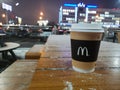 Glass of coffee with logo McDonald `s in winter in summer cafe on the background of night city on January 15, 2020 in Russia,