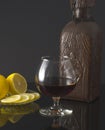 Glass of cognac, bottle and lemon