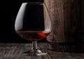 Glass of cognac brandy drink next to wooden barrel. Royalty Free Stock Photo