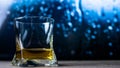 A glass of cognac, brandy, whiskey against a background of drops, whiskey in a glass close-up, against a background of bokeh. Royalty Free Stock Photo