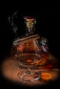 A glass of cognac with a cigarette and a bottle of cognac Royalty Free Stock Photo