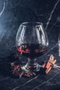 Glass of brandy on a old wooden table with a chocolate, cinnamon sticks Royalty Free Stock Photo