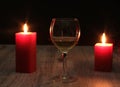 Glass of cognac and red candle on a wooden background Royalty Free Stock Photo