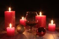 Glass of cognac and red candle on a wooden background Royalty Free Stock Photo