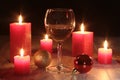 Glass of cognac and red candle on a wooden background Royalty Free Stock Photo