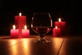 Glass of cognac and red candle on a wooden background Royalty Free Stock Photo