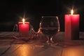 glass of cognac and red candle on a wooden background Royalty Free Stock Photo