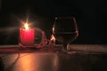 glass of cognac and red candle on a wooden background Royalty Free Stock Photo