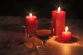 Glass of cognac and red candle on a wooden background Royalty Free Stock Photo