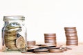 Glass of coin and spread coin on floor on vintage blurred backgr Royalty Free Stock Photo