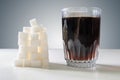 Glass of cola drink and heap of sugar cubec. Unhealthy eating concept Royalty Free Stock Photo
